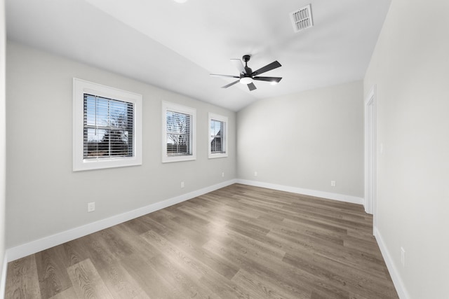 spare room with visible vents, wood finished floors, baseboards, and ceiling fan