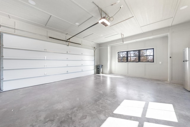 garage featuring a garage door opener and freestanding refrigerator
