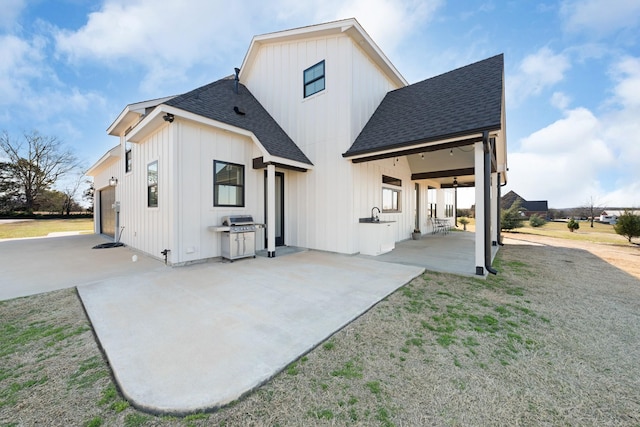 back of property with a patio area, a yard, board and batten siding, and a shingled roof