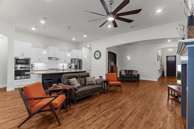 3509 Concord Dr, Melissa, TX 75454 - living room with ceiling fan, wood finished floors, arched walkways, baseboards, and recessed lighting