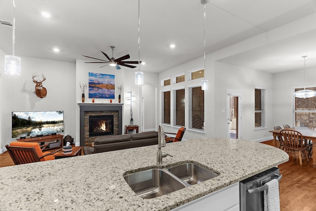 3509 Concord Dr, Melissa, TX 75454 - kitchen with a sink, dishwasher, light wood finished floors, a stone fireplace, and recessed lighting