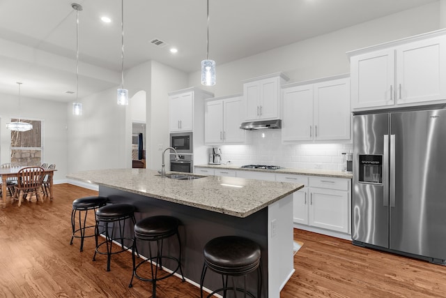 3509 Concord Dr, Melissa, TX 75454 - kitchen with stainless steel appliances, a sink, under cabinet range hood, wood finished floors, and recessed lighting