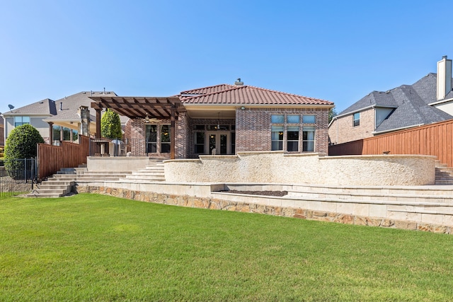 rear view of property featuring a tile roof, a pergola, a lawn, fence, and brick siding