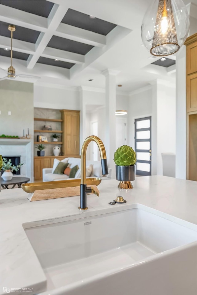 details with crown molding, pendant lighting, a sink, coffered ceiling, and beam ceiling