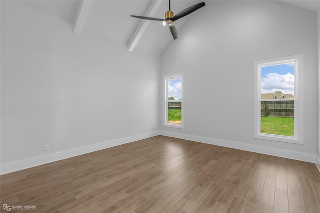 spare room with ceiling fan, high vaulted ceiling, wood finished floors, baseboards, and beam ceiling