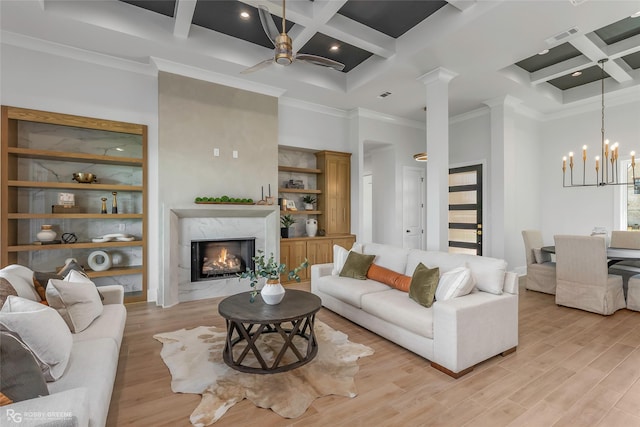 living area with a fireplace, light wood-style flooring, a high ceiling, visible vents, and coffered ceiling