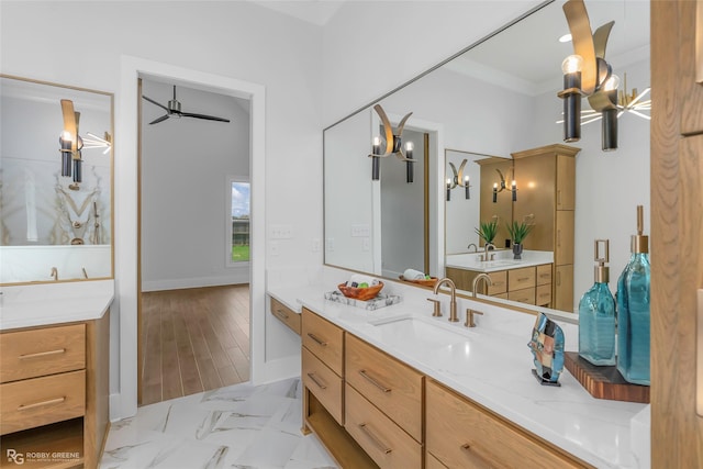 bathroom featuring marble finish floor, two vanities, ceiling fan, and a sink