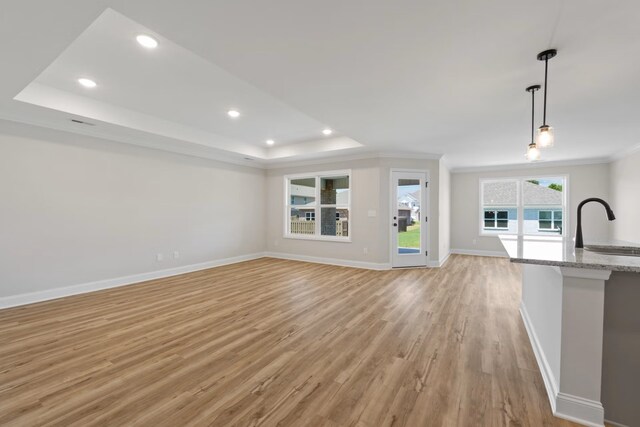 214 Briarwood Dr, Nevada, TX 75173 - unfurnished living room with light wood finished floors, recessed lighting, a raised ceiling, and baseboards