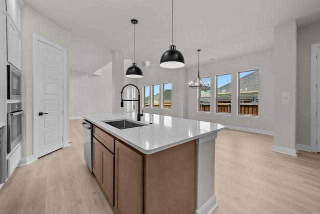 2012 Tolleson Dr, Fort Worth, TX 76008 - kitchen featuring stainless steel appliances, light wood-style floors, light countertops, an island with sink, and pendant lighting