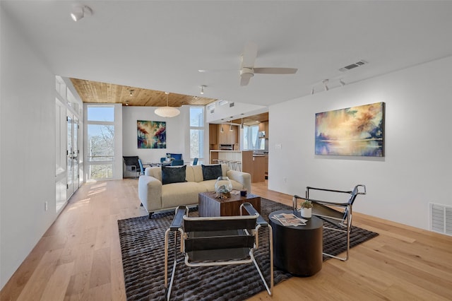 living room featuring ceiling fan, wood ceiling, visible vents, and light wood-type flooring