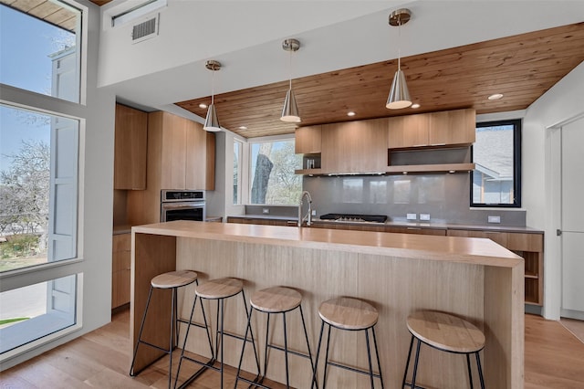 kitchen with open shelves, wooden ceiling, a kitchen breakfast bar, modern cabinets, and backsplash