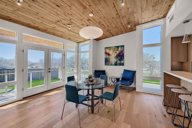 dining area featuring plenty of natural light, light wood-style flooring, french doors, and wooden ceiling