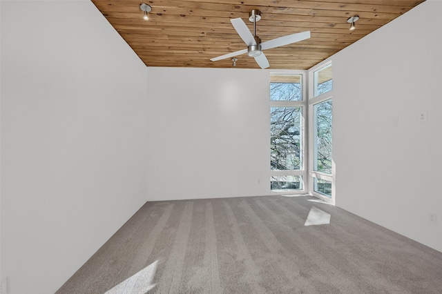 carpeted empty room featuring wooden ceiling, a ceiling fan, and vaulted ceiling