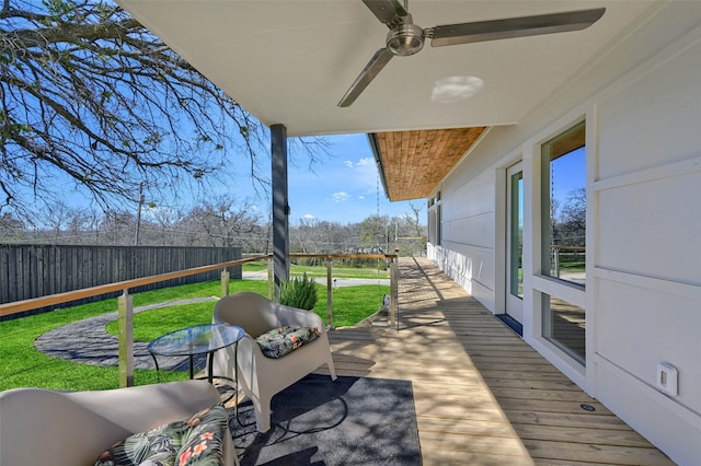 wooden deck featuring a yard and fence