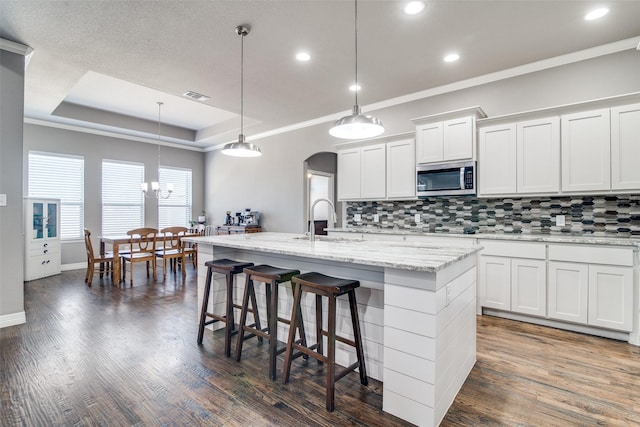 6565 Oak Point Cir, Royse City, TX 75189 - kitchen featuring stainless steel microwave, a sink, decorative backsplash, recessed lighting, and a kitchen island with sink