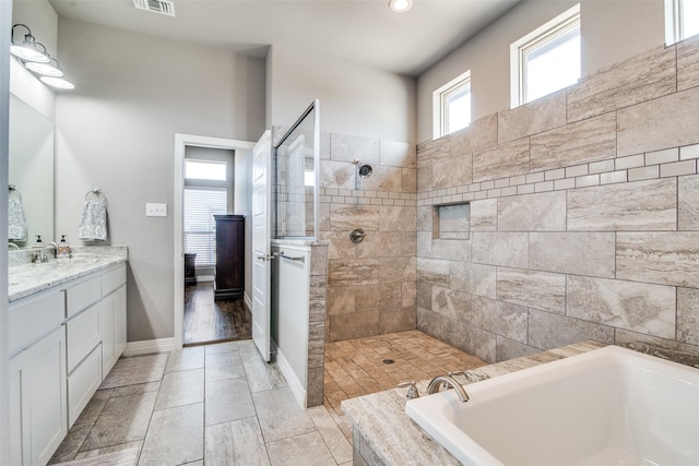 6565 Oak Point Cir, Royse City, TX 75189 - bathroom featuring a garden tub, vanity, a walk in shower, and baseboards