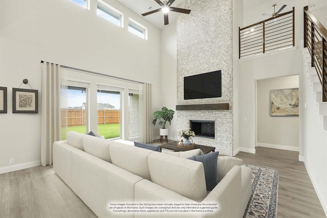 817 Lakewood Ct, Midlothian, TX 76065 - living room featuring a ceiling fan, a towering ceiling, a fireplace, and baseboards