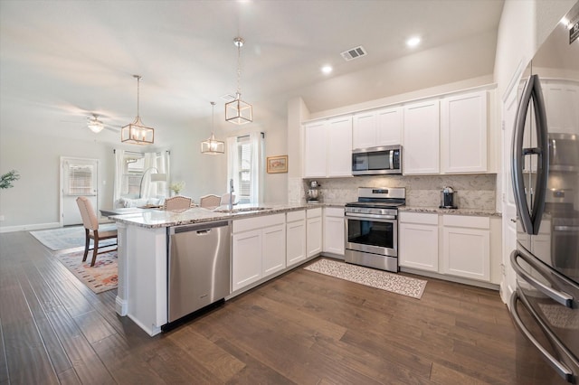kitchen featuring visible vents, appliances with stainless steel finishes, a sink, white cabinets, and a peninsula