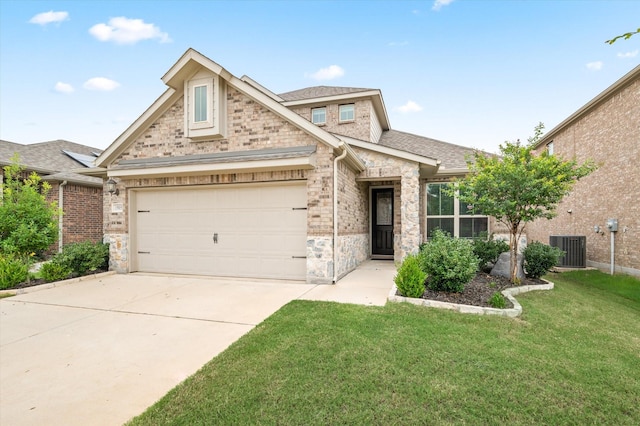 view of front of property with a front yard, central AC, concrete driveway, an attached garage, and stone siding