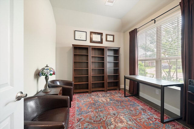 office area with carpet flooring, baseboards, visible vents, and lofted ceiling