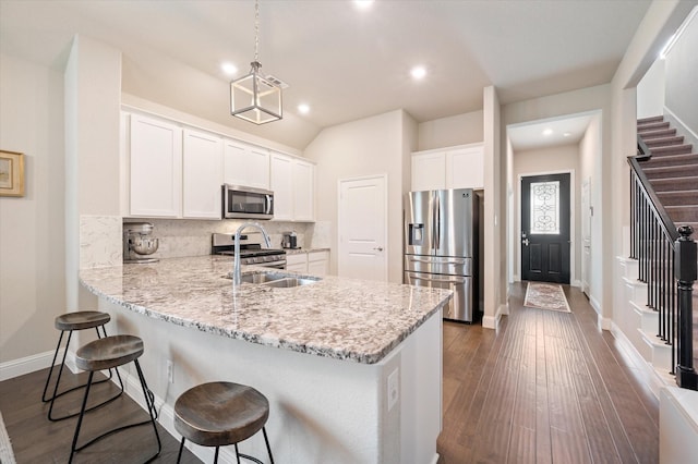 kitchen with a peninsula, recessed lighting, white cabinetry, tasteful backsplash, and appliances with stainless steel finishes