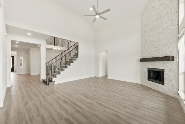 4217 Bel Air Dr, Midlothian, TX 76065 - unfurnished living room featuring stairway, high vaulted ceiling, wood finished floors, ceiling fan, and a fireplace