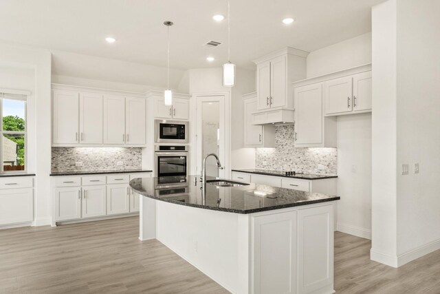 4217 Bel Air Dr, Midlothian, TX 76065 - kitchen featuring stainless steel oven, a sink, black microwave, light wood-type flooring, and backsplash