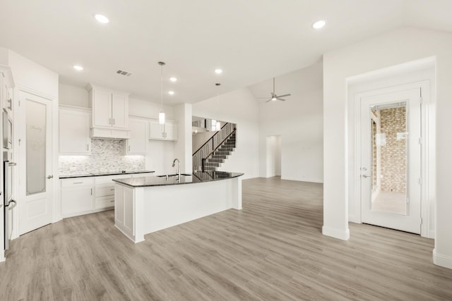4217 Bel Air Dr, Midlothian, TX 76065 - kitchen featuring a sink, lofted ceiling, dark countertops, light wood-style flooring, and tasteful backsplash