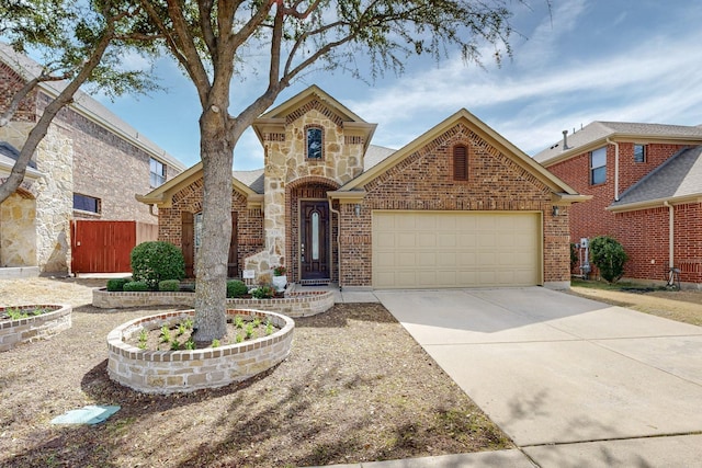 view of front of property featuring brick siding, fence, concrete driveway, stone siding, and an attached garage