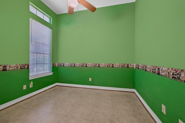 tiled spare room featuring a wealth of natural light, baseboards, and ceiling fan
