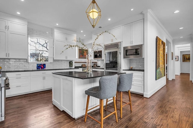 8604 Baltusrol Dr, Flower Mound, TX 75022 - kitchen with appliances with stainless steel finishes, decorative backsplash, dark countertops, recessed lighting, and white cabinets