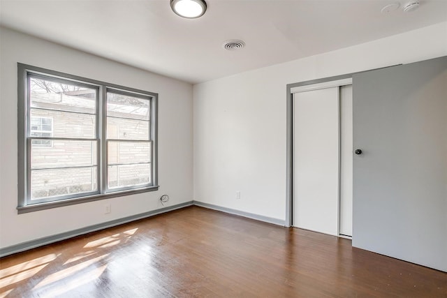 1036 Springer Ave, Fort Worth, TX 76114 - unfurnished bedroom featuring multiple windows, wood finished floors, and a closet