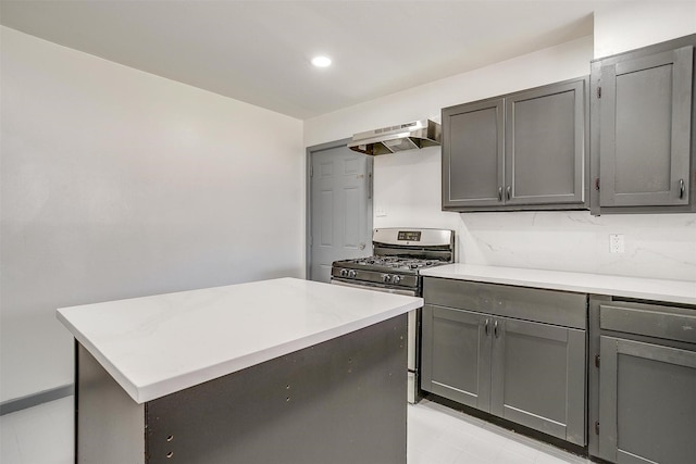 1036 Springer Ave, Fort Worth, TX 76114 - kitchen with under cabinet range hood, stainless steel gas stove, gray cabinetry, a center island, and recessed lighting