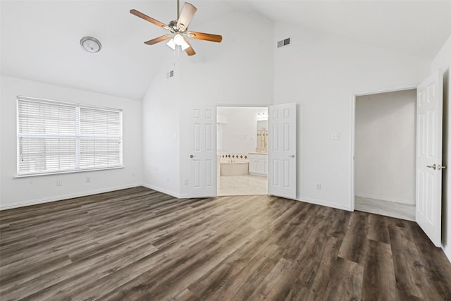 unfurnished bedroom featuring high vaulted ceiling, dark wood-style flooring, ensuite bathroom, baseboards, and ceiling fan