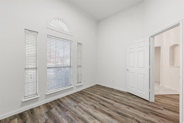 spare room with dark wood finished floors and baseboards