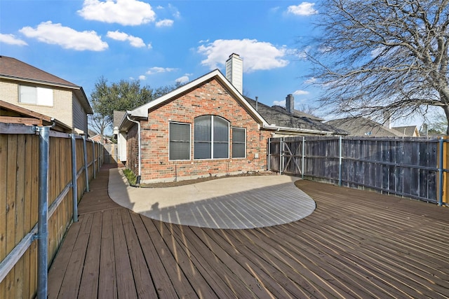 wooden terrace with a fenced backyard
