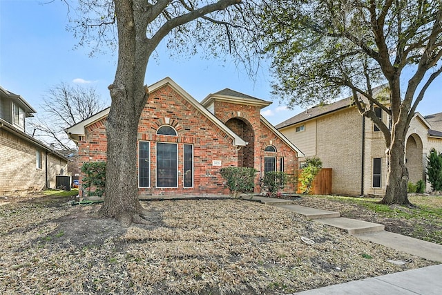 traditional-style house featuring brick siding and central AC