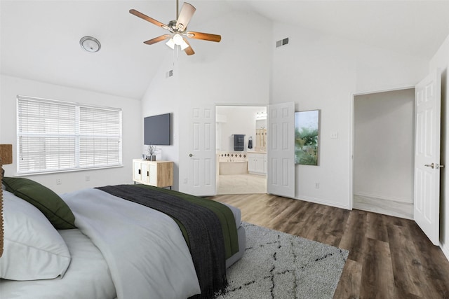 bedroom featuring high vaulted ceiling, wood finished floors, ensuite bath, baseboards, and a ceiling fan