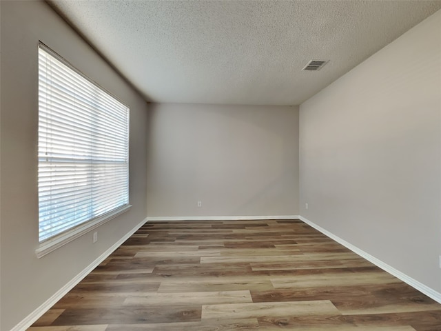 1114 Huntington Trl, Mansfield, TX 76063 - unfurnished room with visible vents, baseboards, a textured ceiling, and wood finished floors