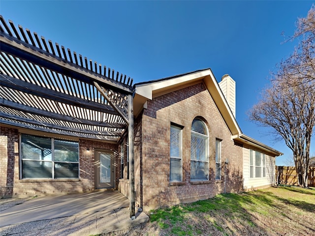 1114 Huntington Trl, Mansfield, TX 76063 - view of side of property featuring brick siding, fence, a lawn, a chimney, and a pergola