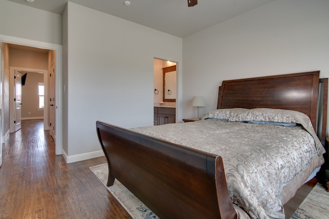 bedroom with baseboards, dark wood finished floors, and connected bathroom
