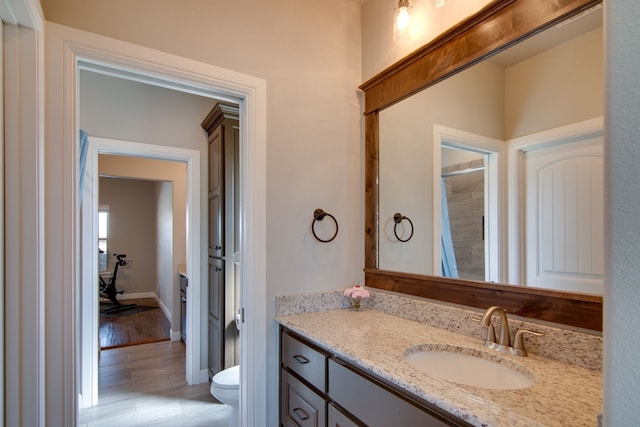 full bath with toilet, baseboards, and vanity