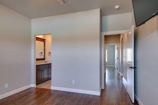 empty room with baseboards, visible vents, and wood finished floors