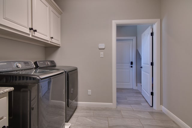 laundry room featuring baseboards, cabinet space, and washer and dryer
