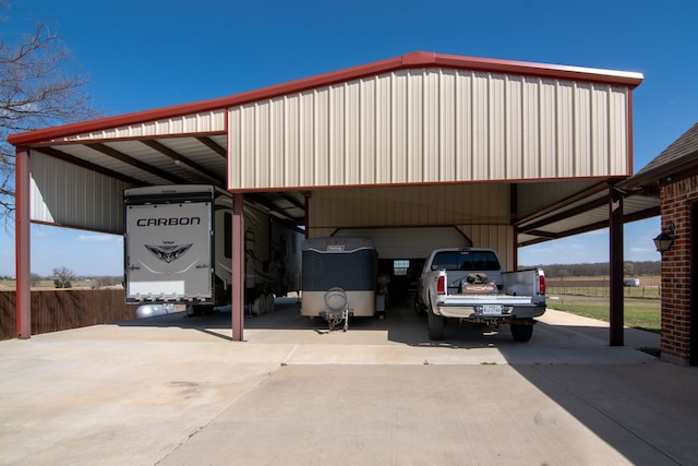 view of car parking featuring fence and concrete driveway