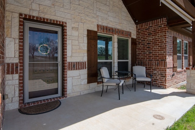 property entrance featuring stone siding and brick siding