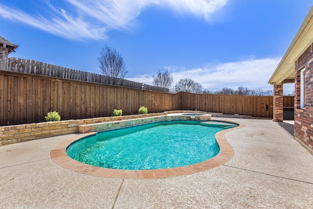 view of swimming pool with a fenced backyard, a pool with connected hot tub, and a patio area