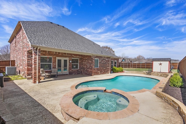 view of swimming pool featuring a fenced backyard, central AC unit, a patio area, french doors, and a shed
