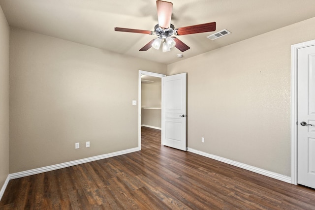unfurnished bedroom with dark wood-style flooring, visible vents, a ceiling fan, and baseboards