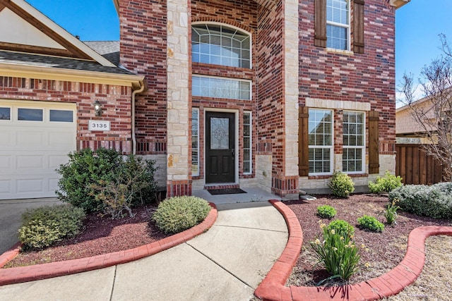 property entrance featuring a garage, brick siding, fence, and roof with shingles